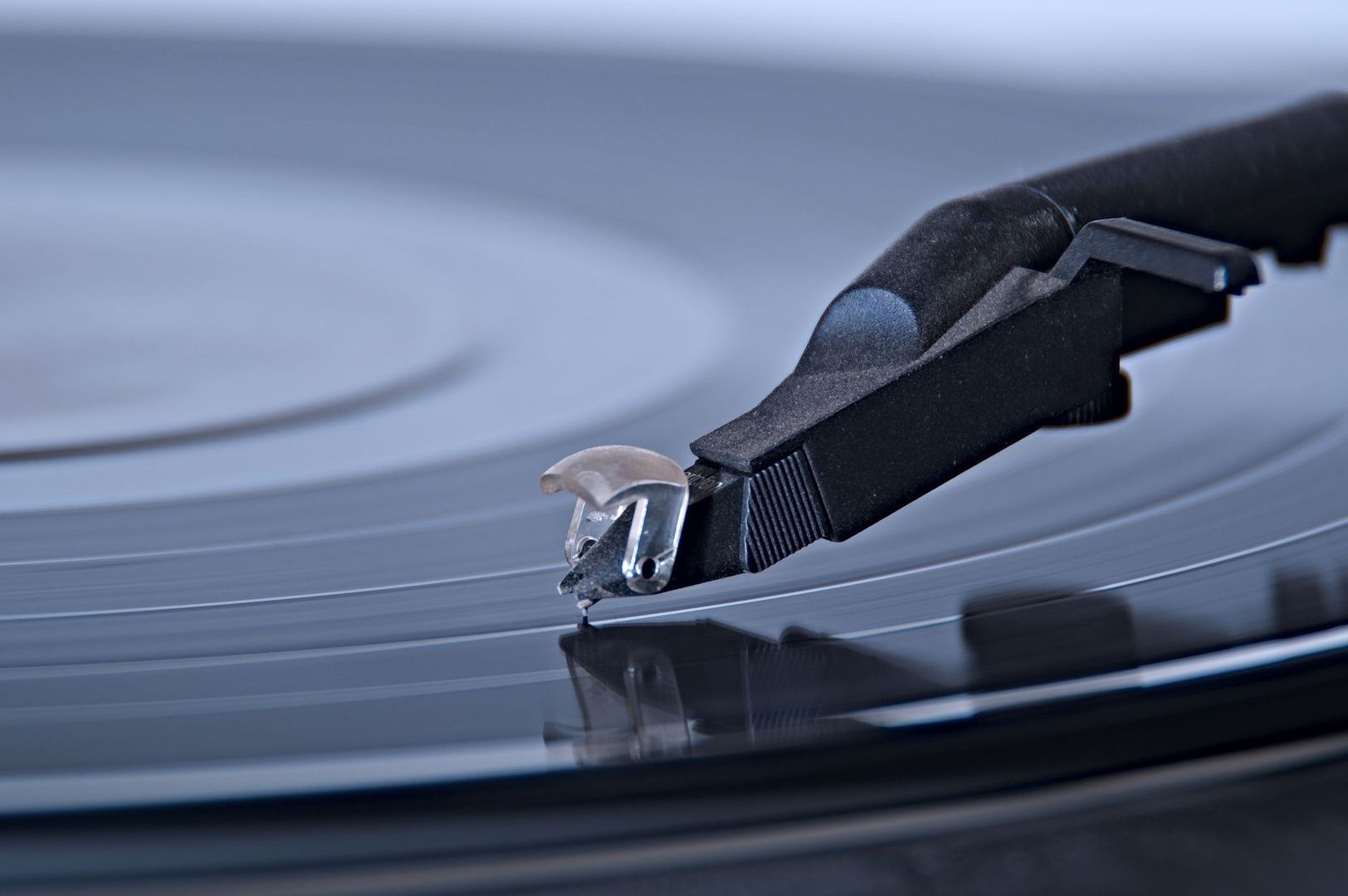 Närbild av tonarm och pickup som spelar en vinylskiva